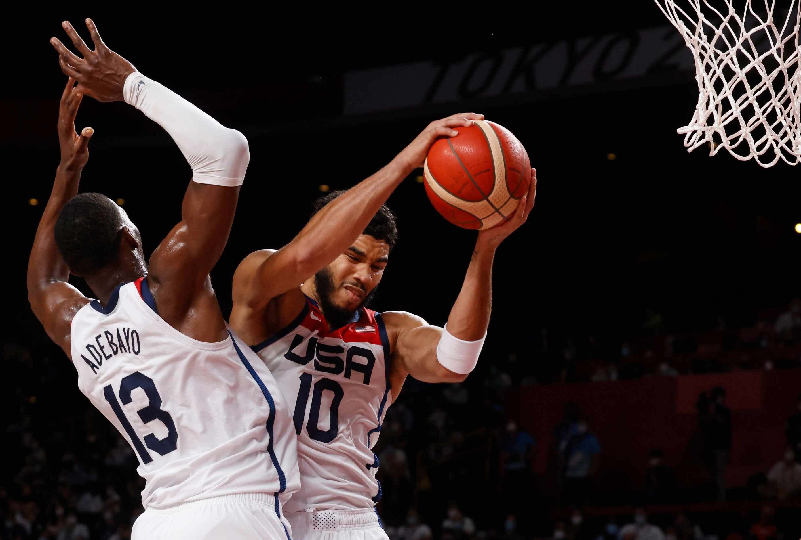 USA’s Jayson Tatum (10) secures a rebound in front of teammate Bam Adebayo (13) in a game...