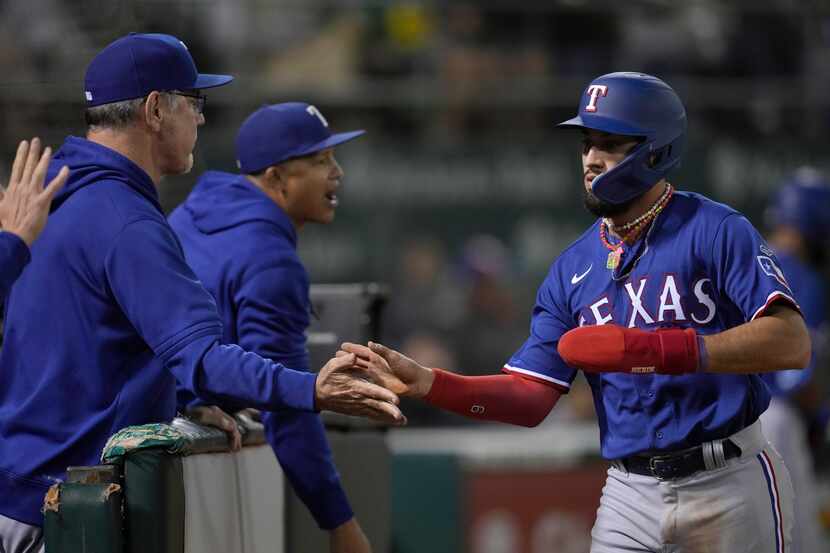 Texas Rangers' Jonathan Ornelas, right, is congratulated by manager Bruce Bochy, left, after...