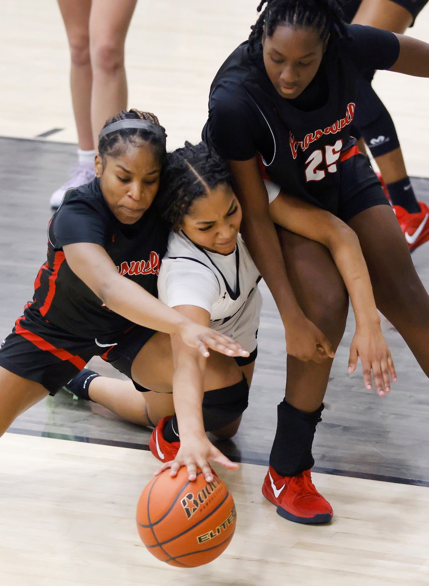 Denton Guyer guard Destanie Green (center)  is squeezed out by Denton Braswell’s Hannah...