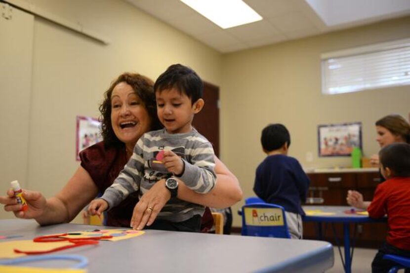 
Maria Stacy, Spanish translator, helps Oscar Leon work on an art project during the Bridge...