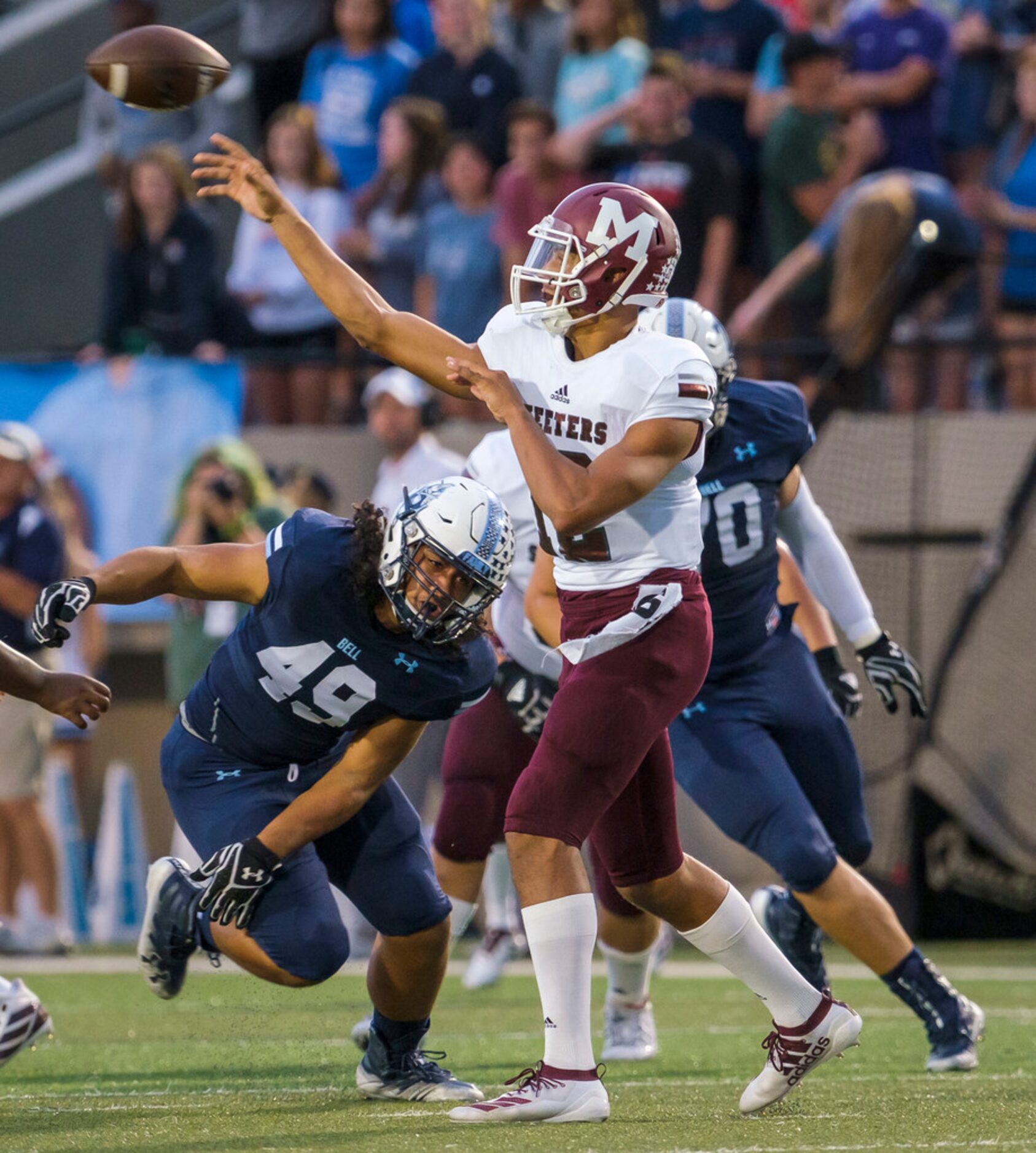 Mesquite quarterback Dylan Hillard-McGill (12) throws a pass under pressure from L.D. Bell...