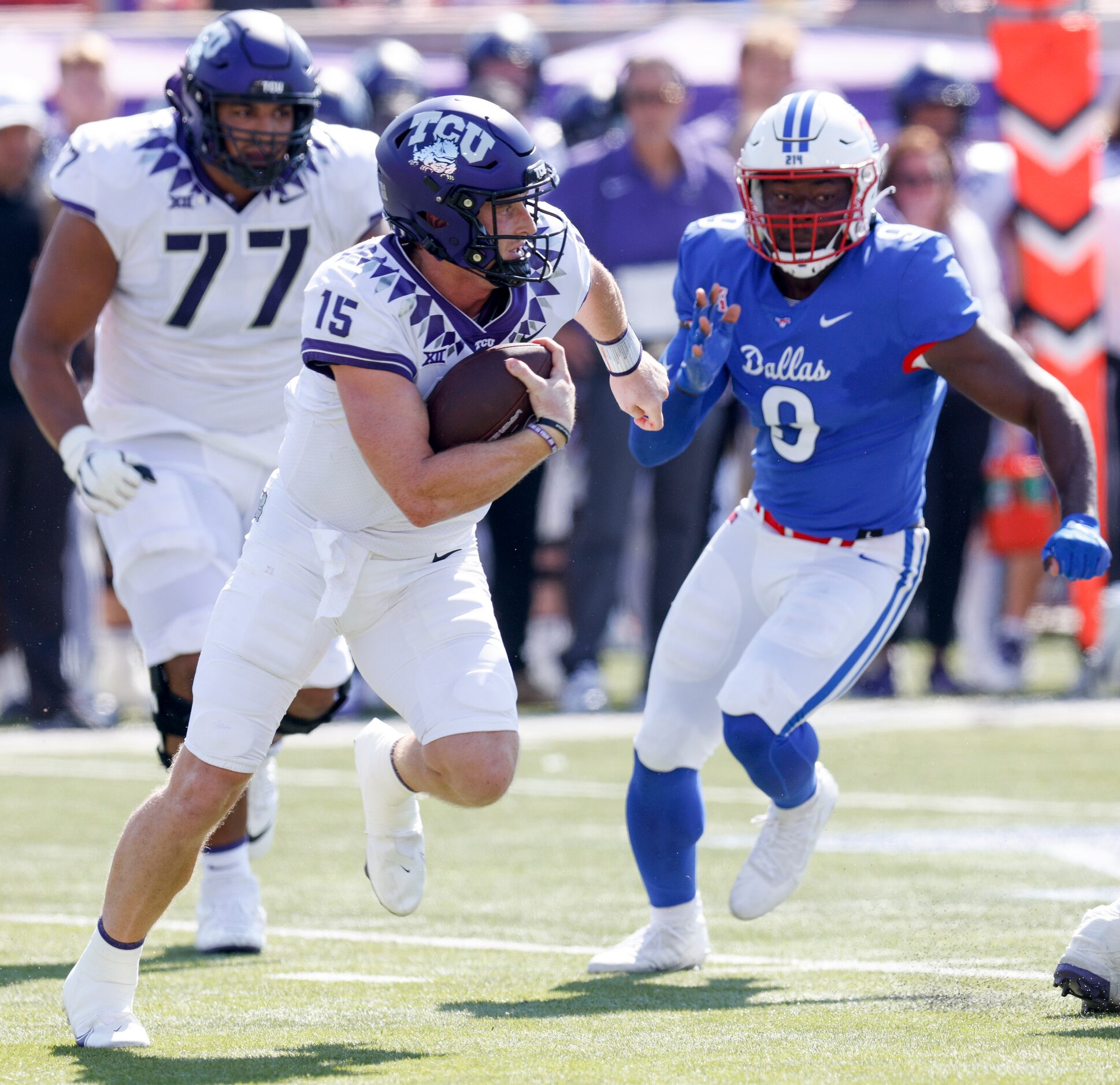 TCU quarterback Max Duggan (15) runs the ball away from SMU defensive end Nelson Paul (9)...