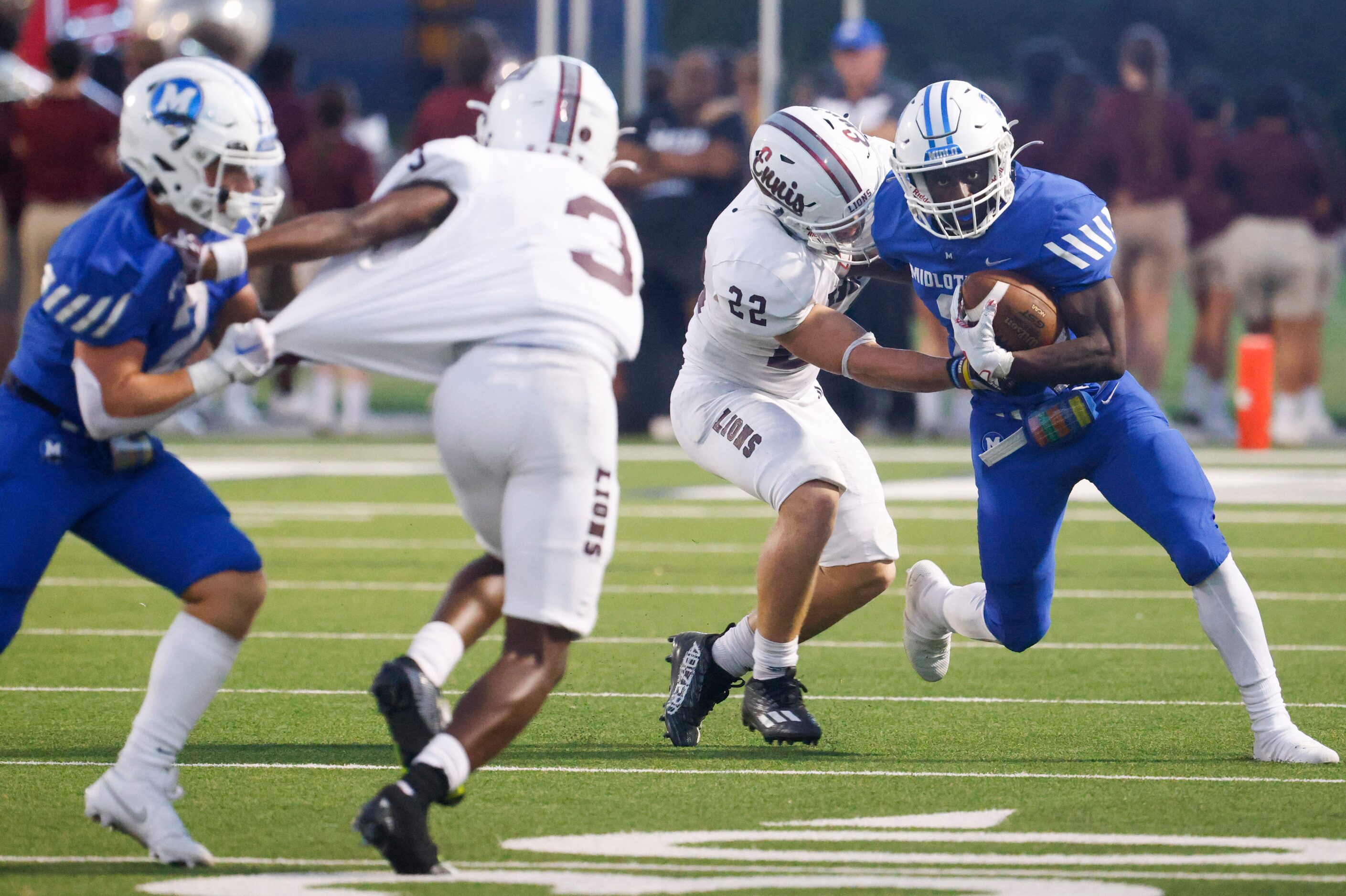 Ennis’ Malachi Perez (22) tackles Midlothian’s David Aborisade (far right) during the first...