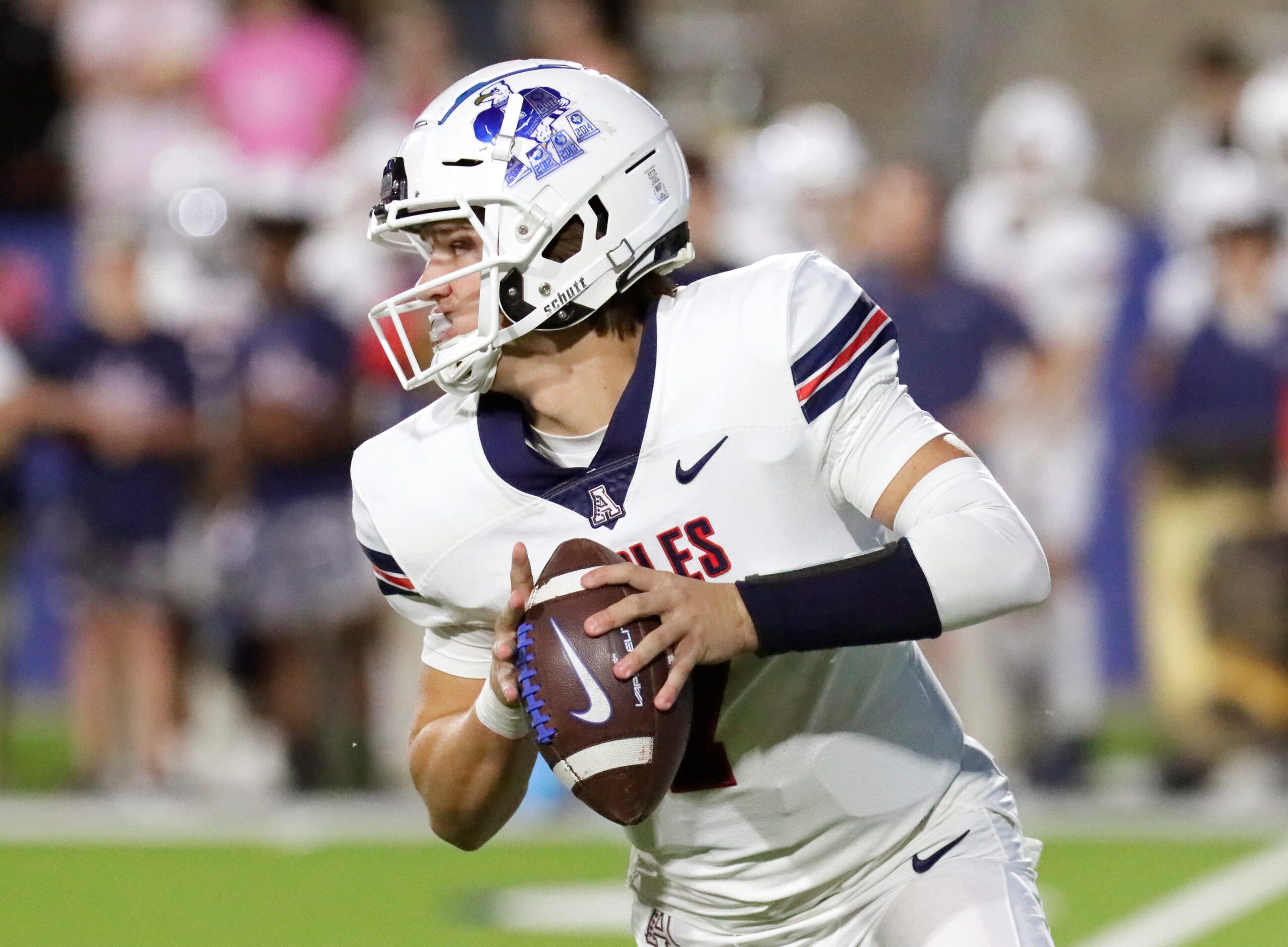 Allen High School quarterback Brady Bricker (7) looks for a passing option during the first...