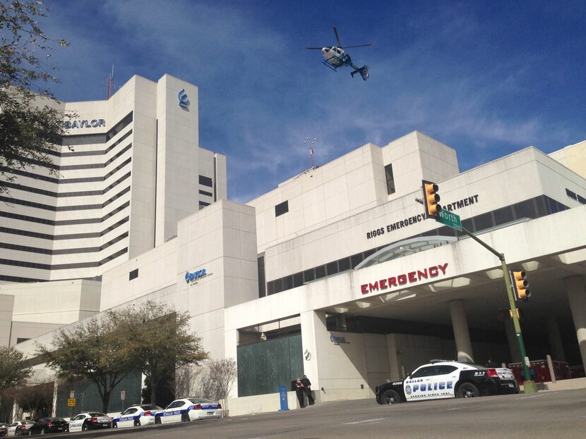 Dallas Police officers wait outside Baylor University Medical Center in Dallas after one of...