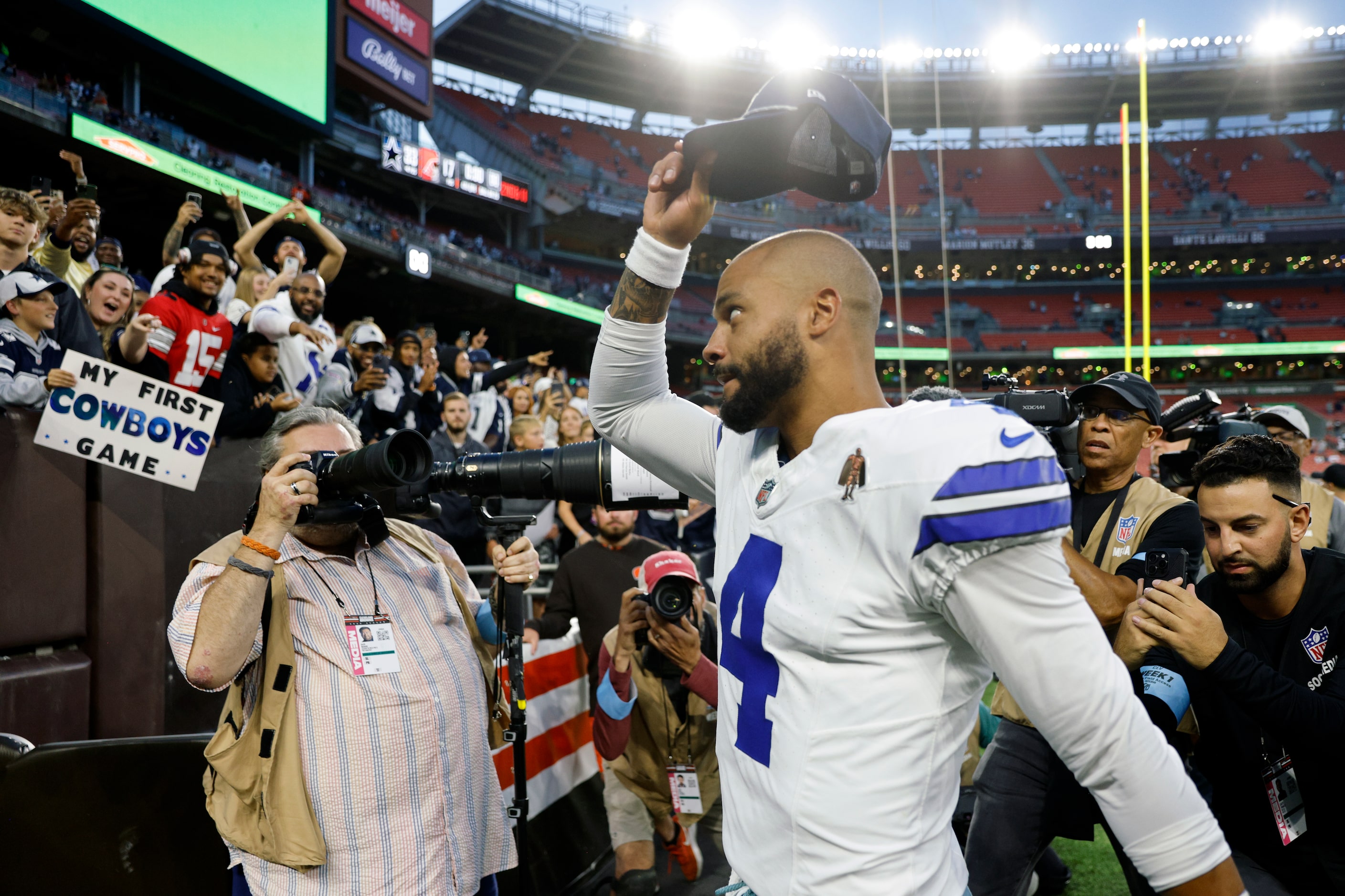 Dallas Cowboys quarterback Dak Prescott tosses his hat to fans after a game against the...