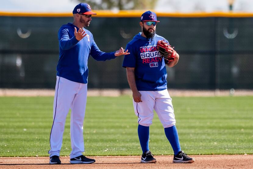 Texas Rangers manager Chris Woodward (left) talks with second baseman Rougned Odor during a...