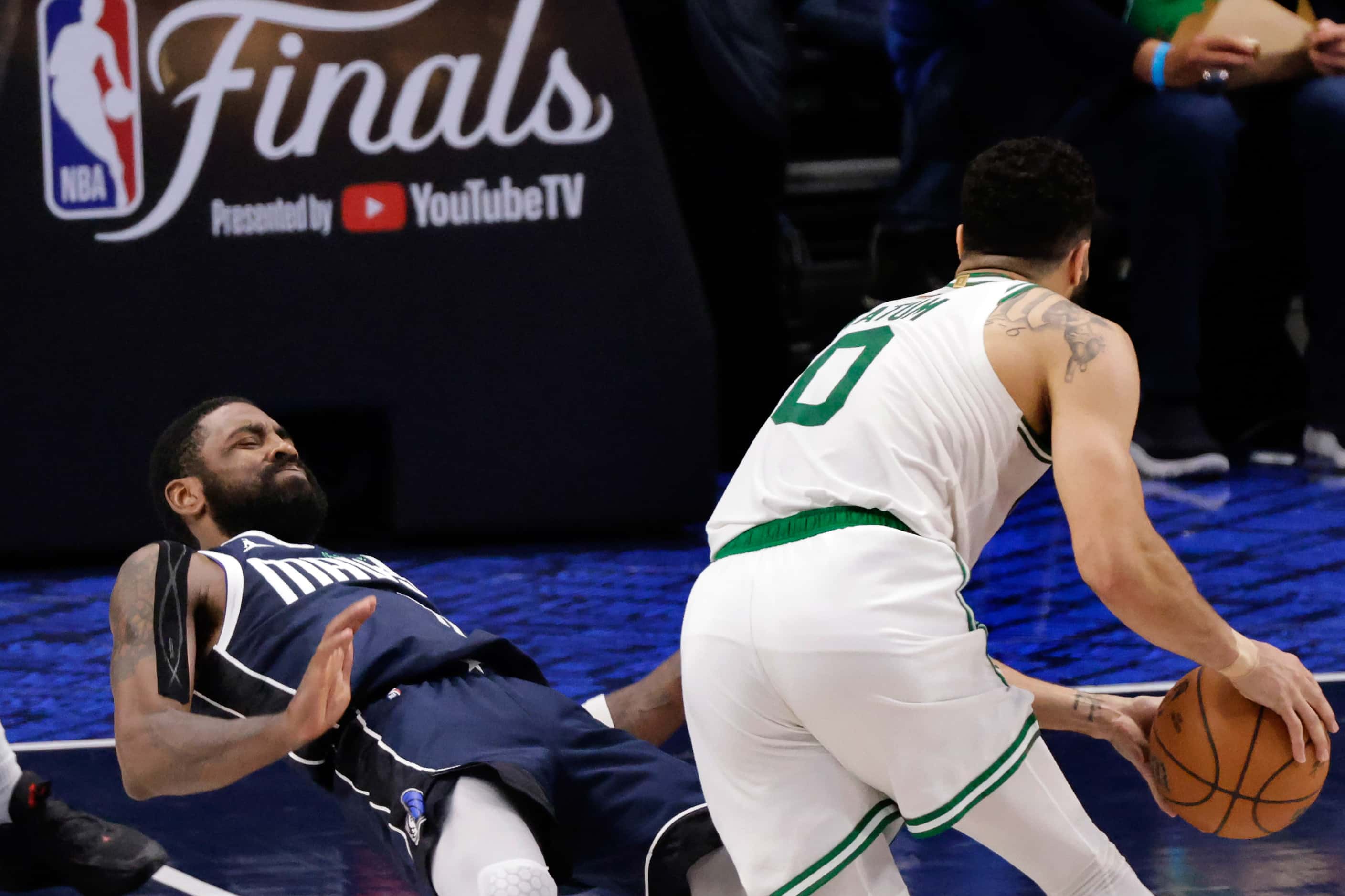 Dallas Mavericks guard Kyrie Irving (11) takes the charge from Boston Celtics forward Jayson...