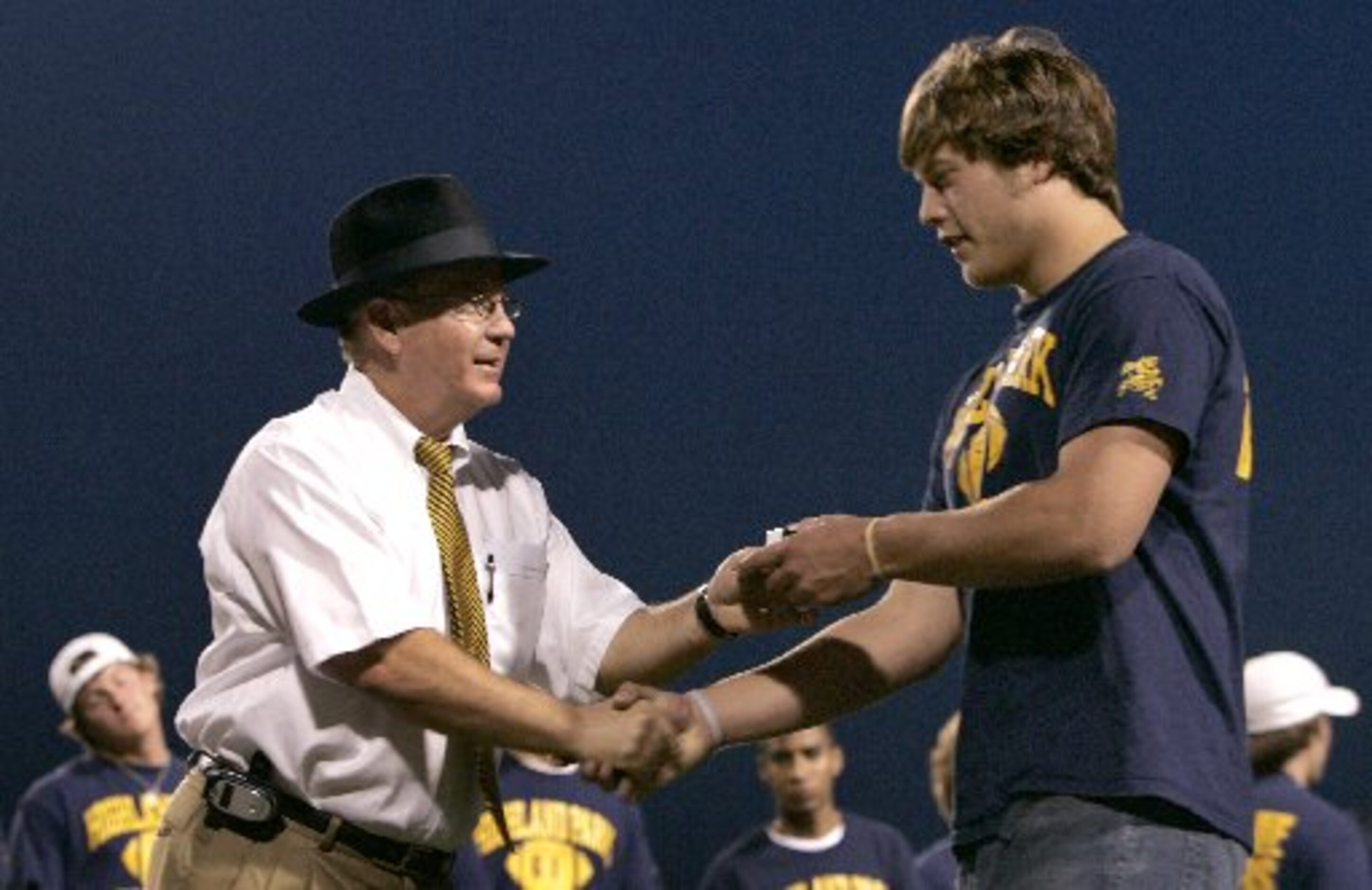 Highland Park football head coach Randy Allen presents quarterback Matthew Stafford with his...