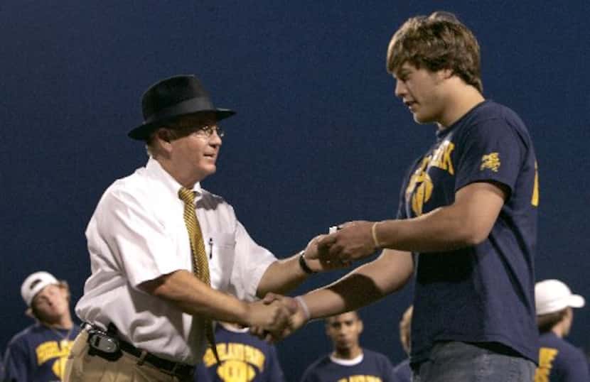 Highland Park football head coach Randy Allen presents quarterback Matthew Stafford with his...