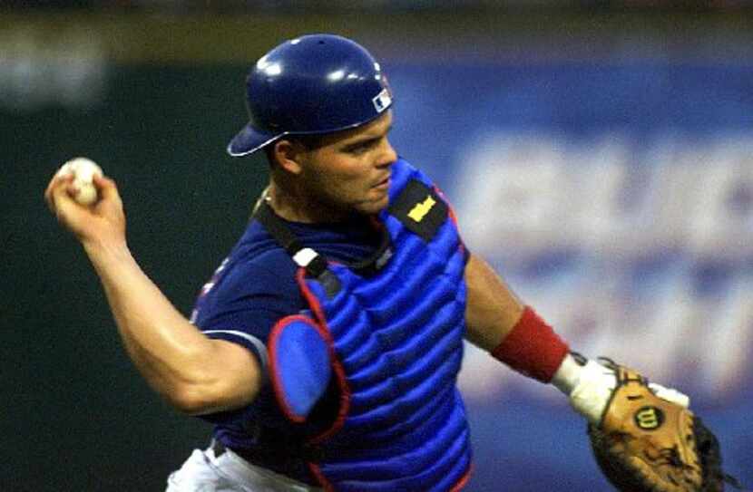 Texas Rangers' catcher Ivan 'Pudge' Rodriguez (7) throws out a runner at first base on a...