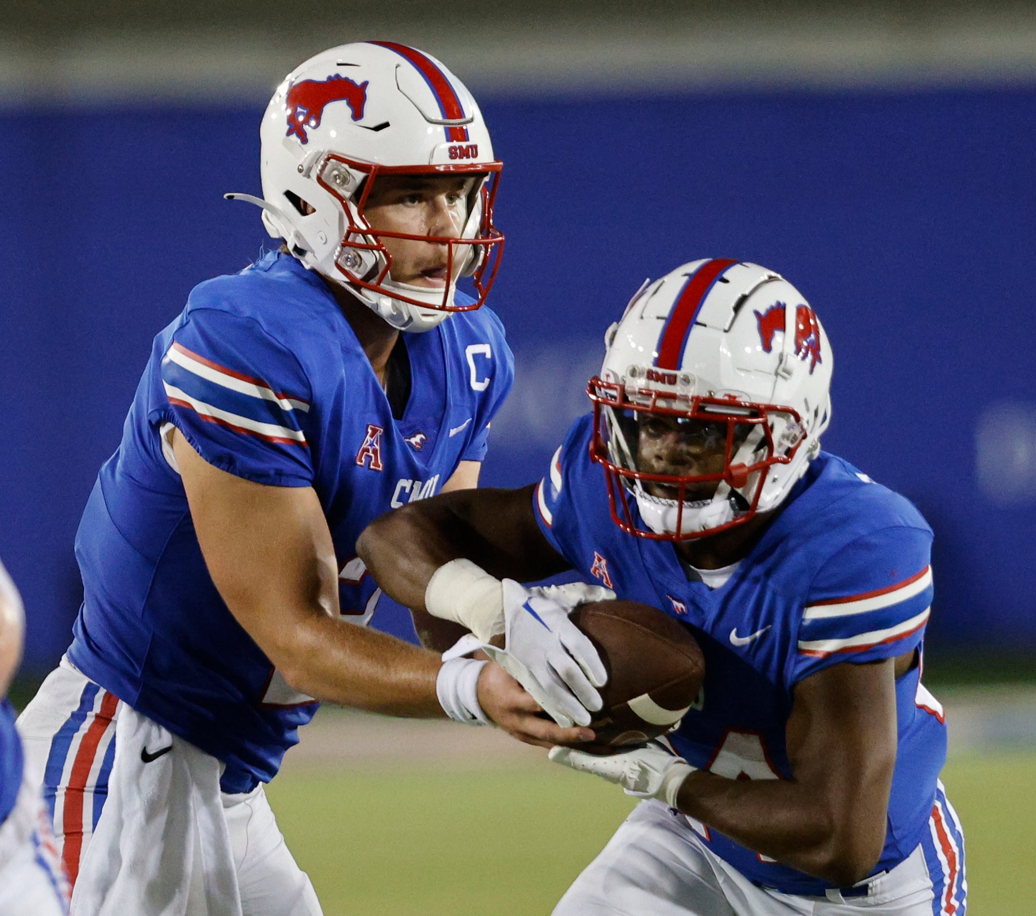 SMU quarterback Preston Stone (2), left, hands off to SMU running back Velton Gardner (24)...