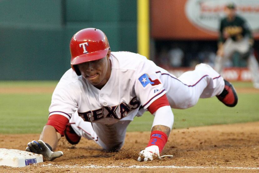 Texas Rangers center fielder Leonys Martin (2) dives back to first safely in the third...