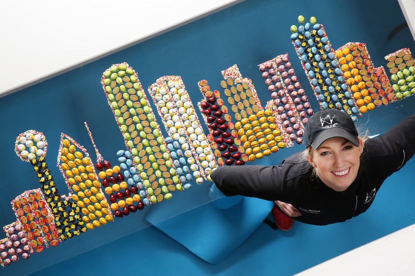 Kate Weiser, chocolatier, poses for a photograph next to her Dallas skyline made with her...