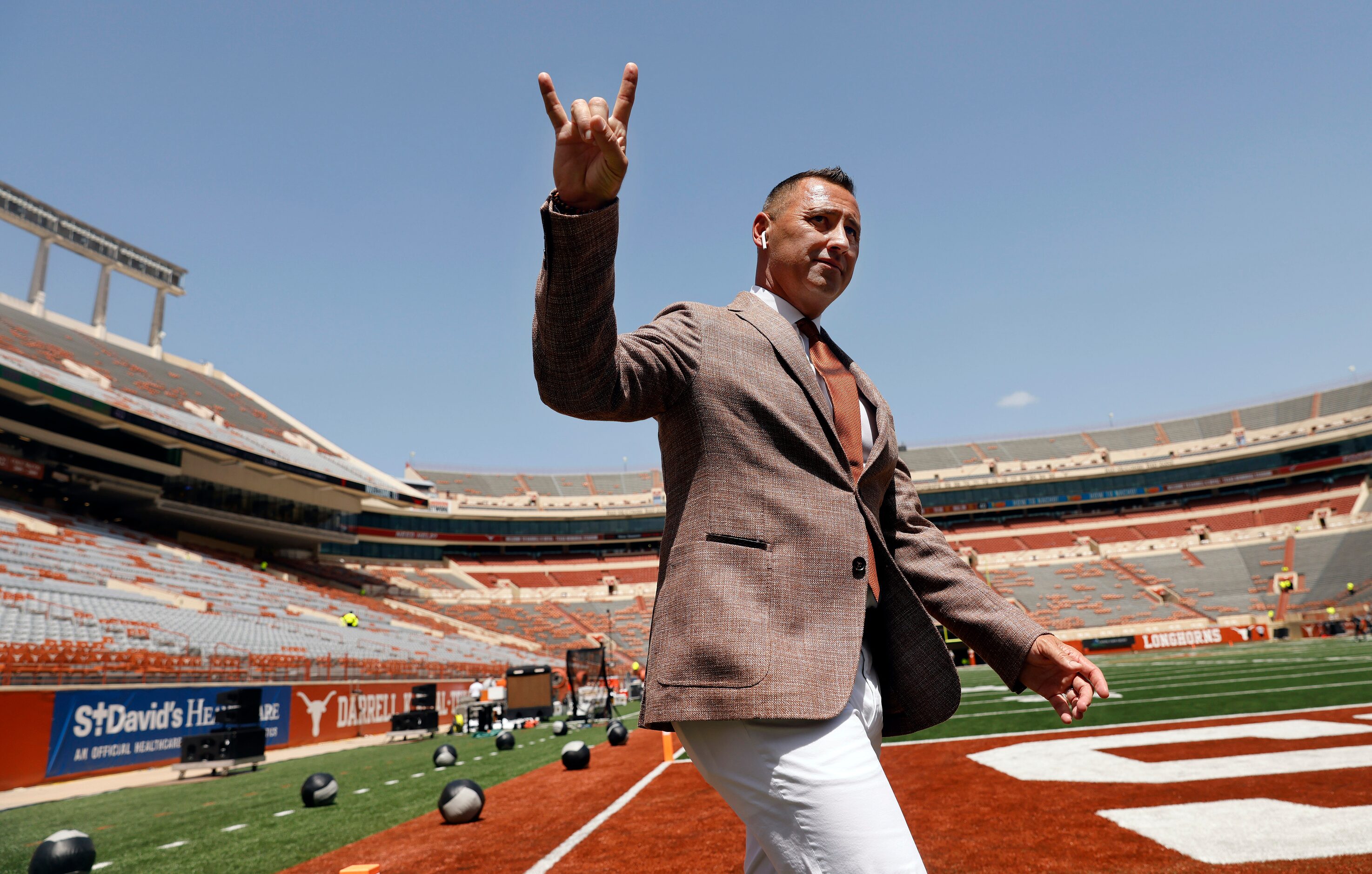 Texas Longhorns head coach Steve Sarkisian gives the Hook'em Horns hand sign as he paces the...