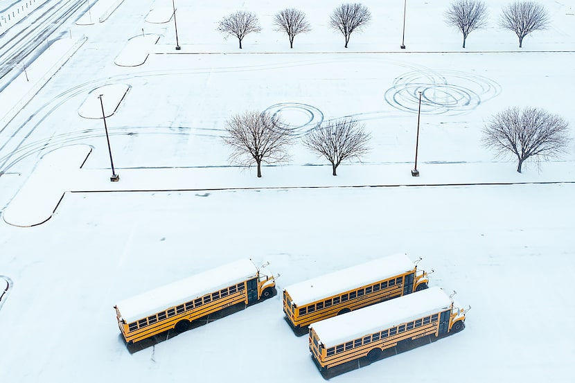 Autobuses escolares bajo la nieve en la Plano Senior High School el jueves 9 de enero de...