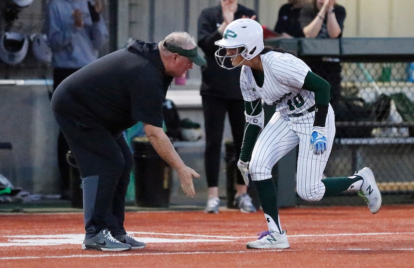 Prosper High School infielder Gabby Coffey (10) low fives Prosper High School head coach...