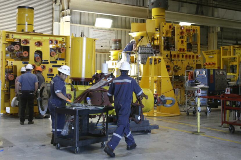 Employees at FMC Technology in Houston work to develop drilling equipment that can withstand...