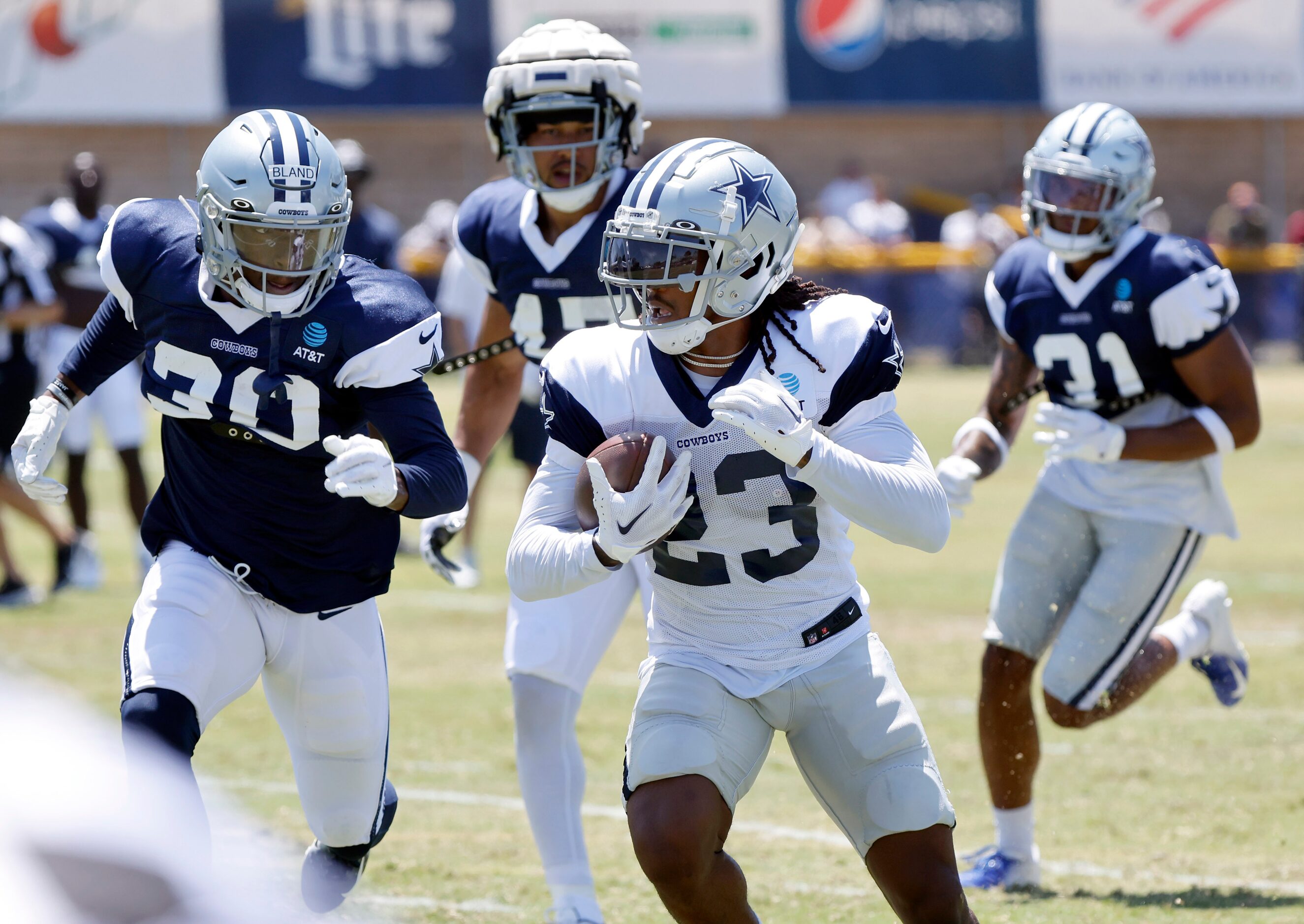 Dallas Cowboys running back Rico Dowdle (23) is pursued by cornerback DaRon Bland (30) and...