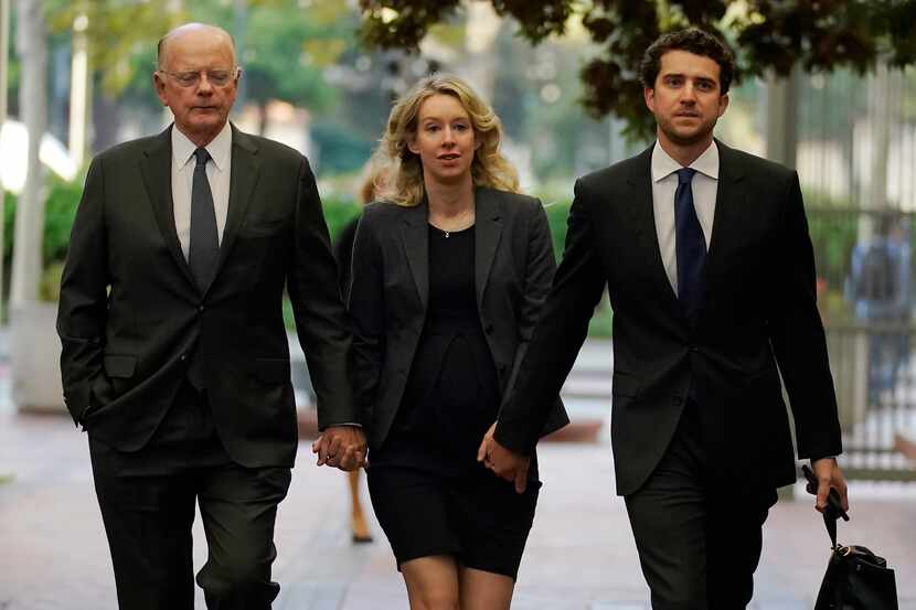 Former Theranos CEO Elizabeth Holmes, center, arrived at federal court in California in 2022...