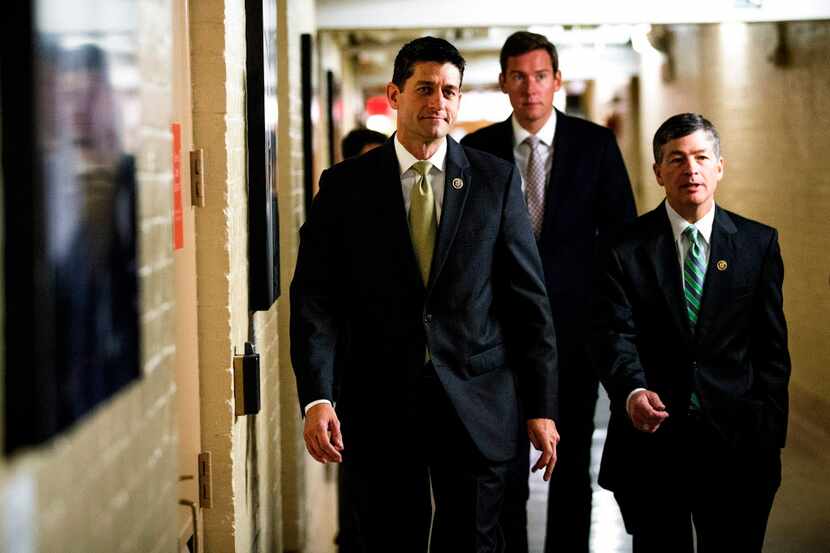  Rep. Paul Ryan, left, heads to aÂ GOP caucus meeting at the Capitol on Oct. 21, before his...