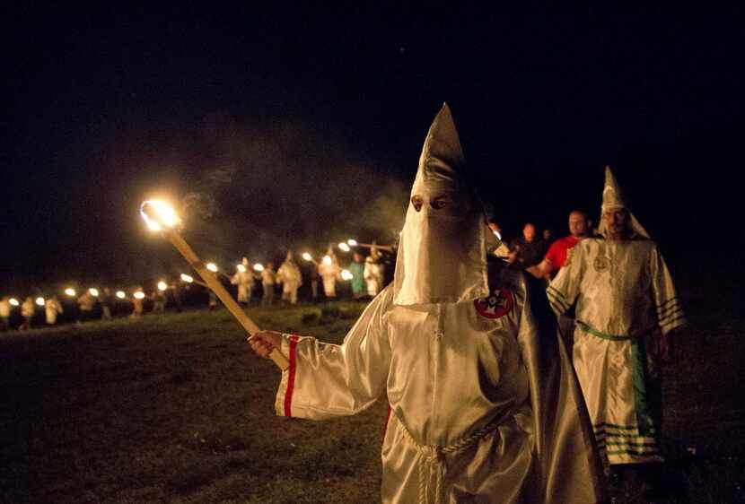 In this Saturday, April 23, 2016 photo, members of the Ku Klux Klan participate in cross...