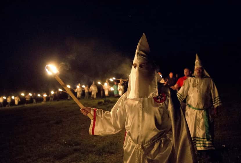 In this Saturday, April 23, 2016 photo, members of the Ku Klux Klan participate in cross...