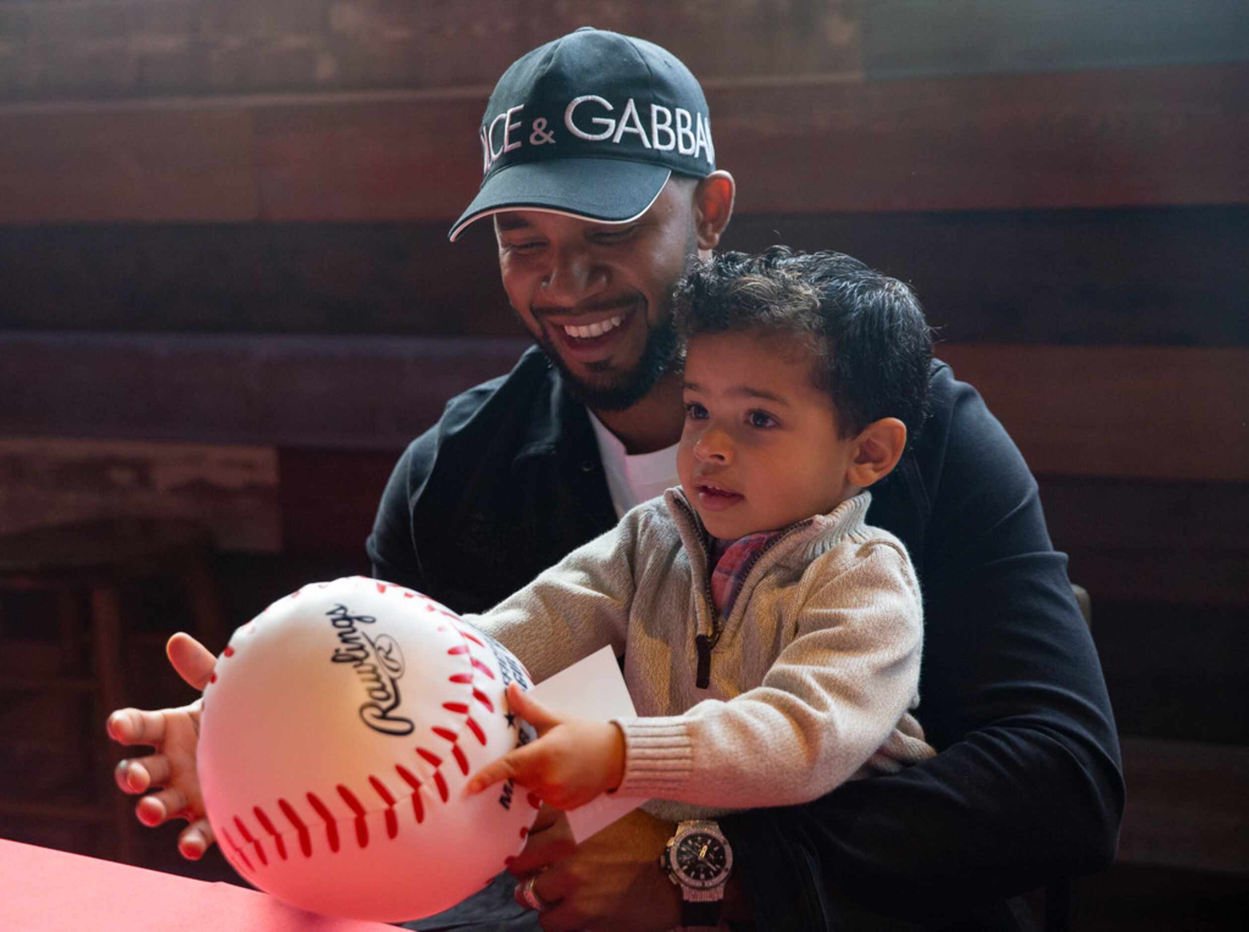 Texas Rangers shortstop Elvis Andrus (1) signs autographs while holding his son during the...