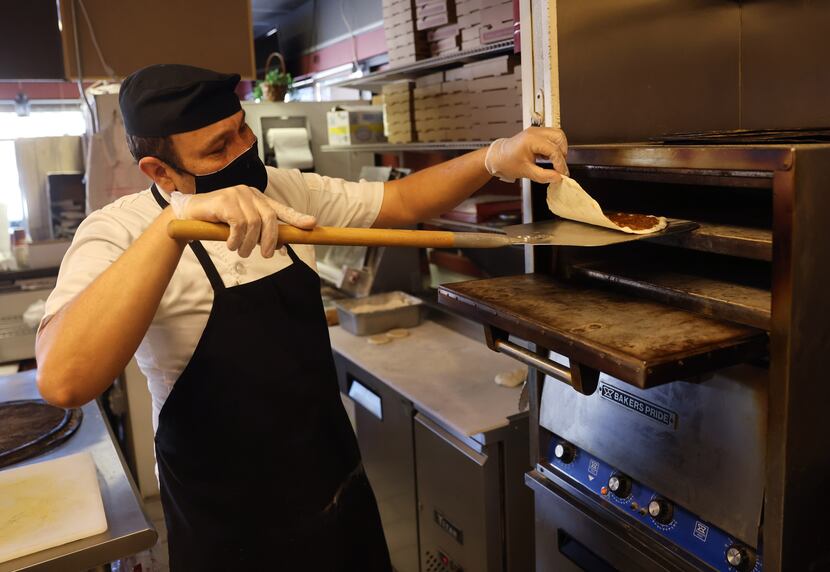 Lezzet Cafe chef-owner Guych Yazgeldi checks a lahmacun, or Armenian pizza, as it comes out...