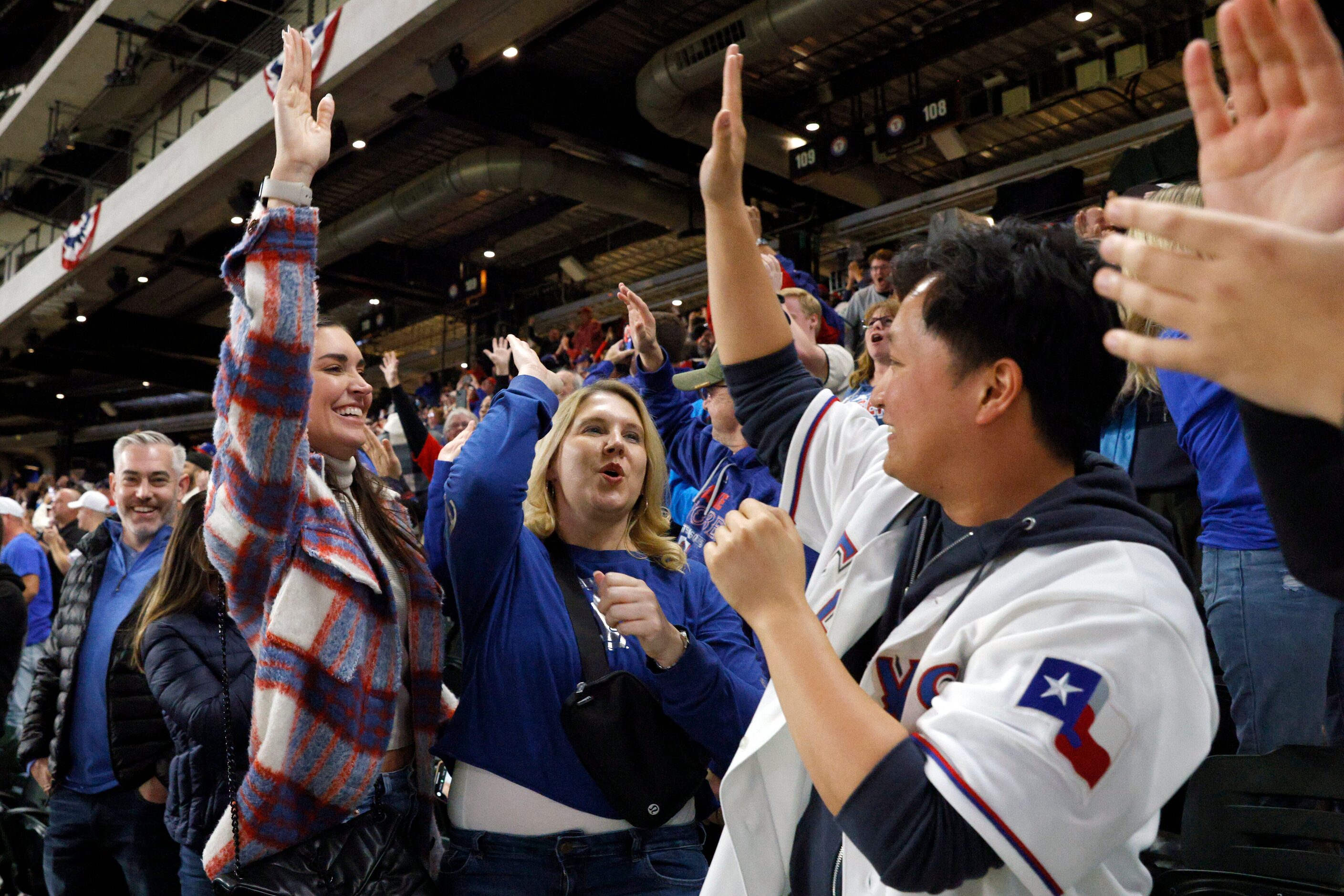 Mallory Pittman (left), Amy Langschied (center) and Andrew Sun high-five after the Texas...