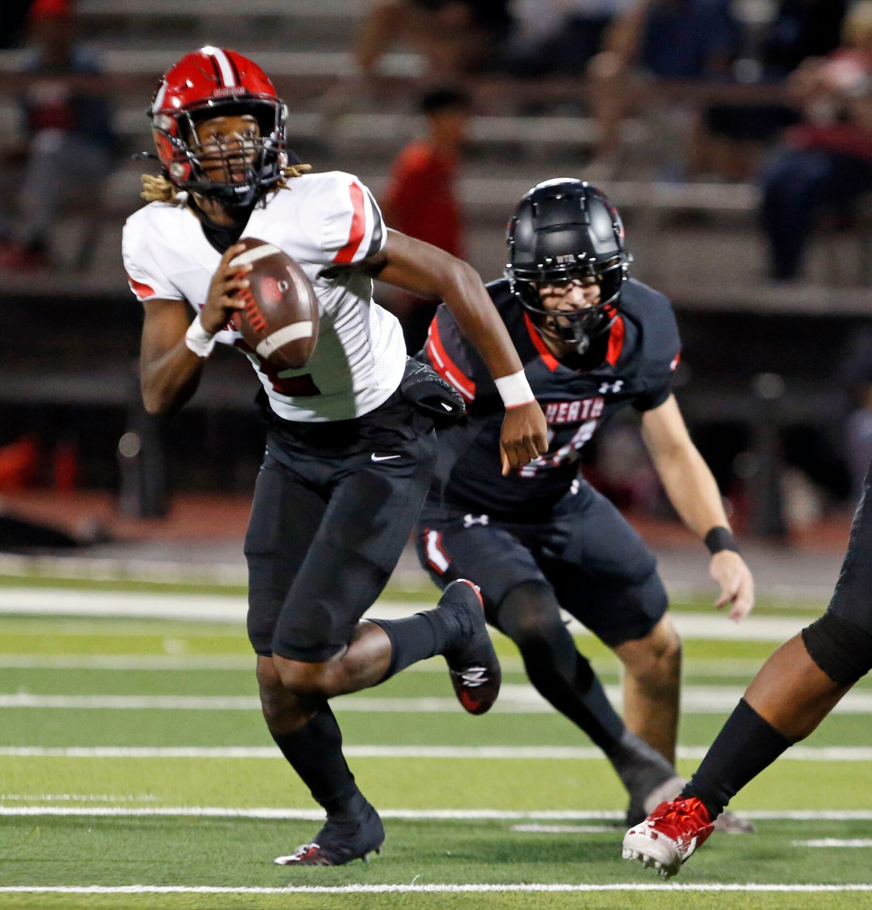 Mesquite Horn QB J.T. Thomas (2) scrambles from a Rockwall Heath defender during the first...