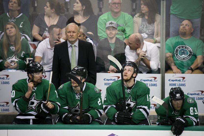 Dallas Stars head coach Lindy Ruff stands over a somber bench during the third period of a...