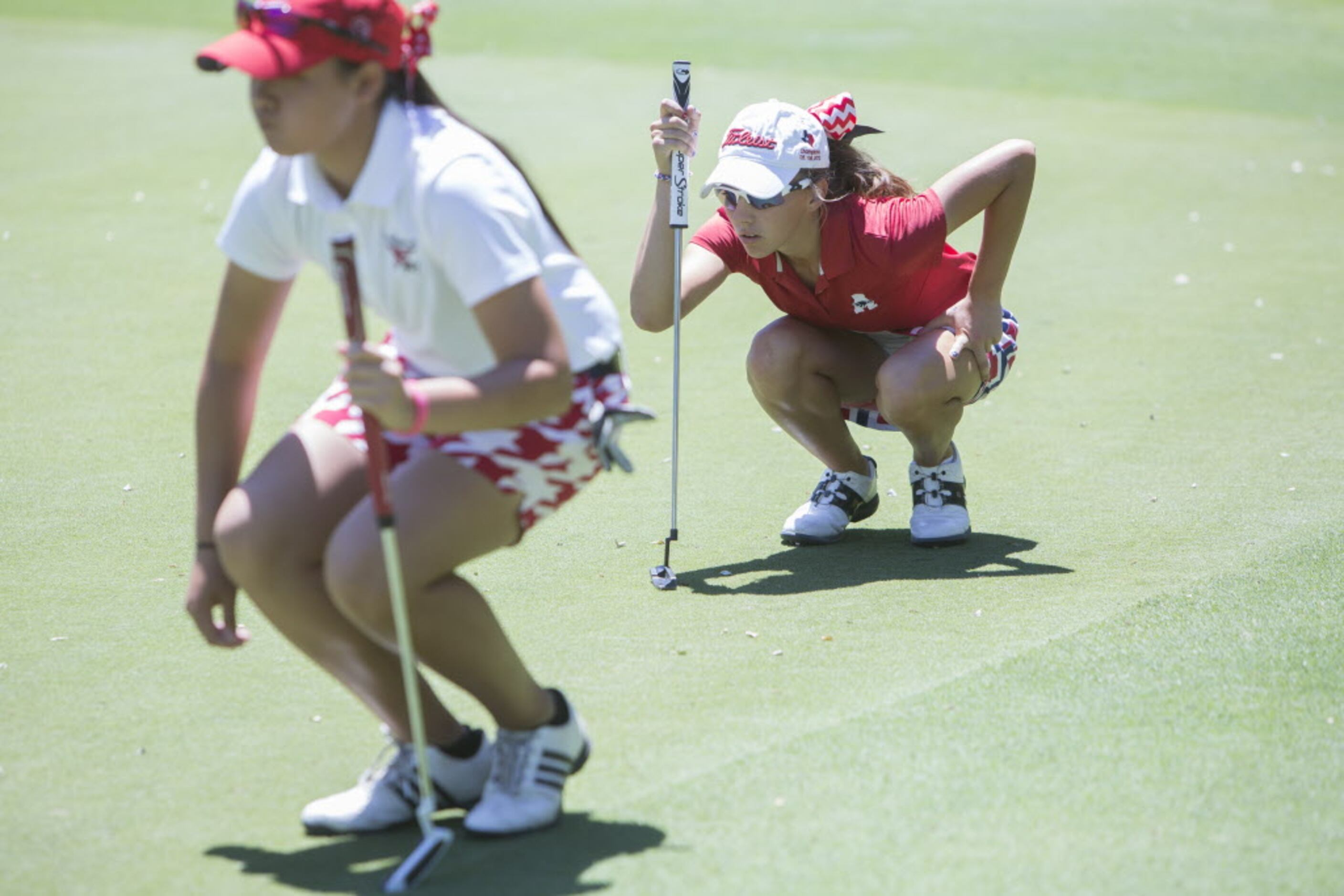 Allen junior Julie Houston, right, lines up a putt on the second green during the UIL 5A...