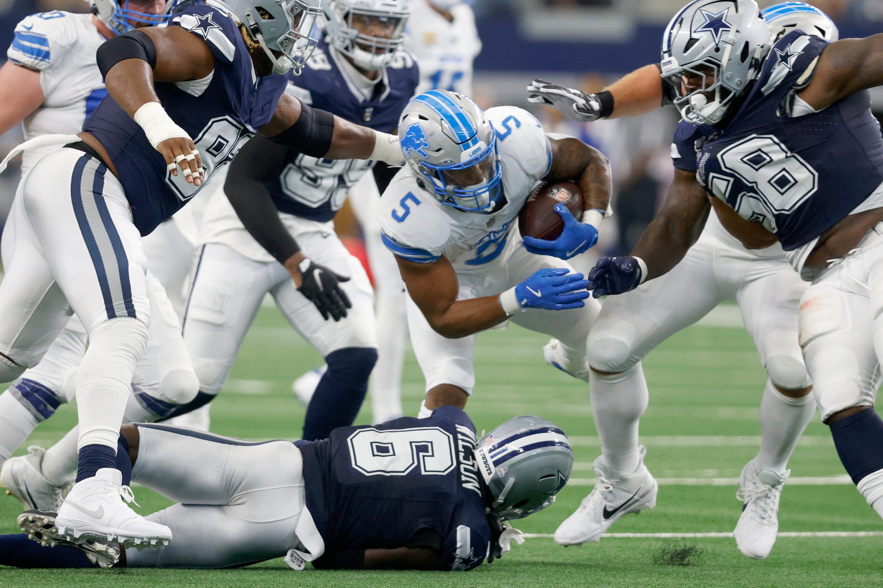 Dallas Cowboys defense players tries to stop Detroit Lions running back David Montgomery (5)...