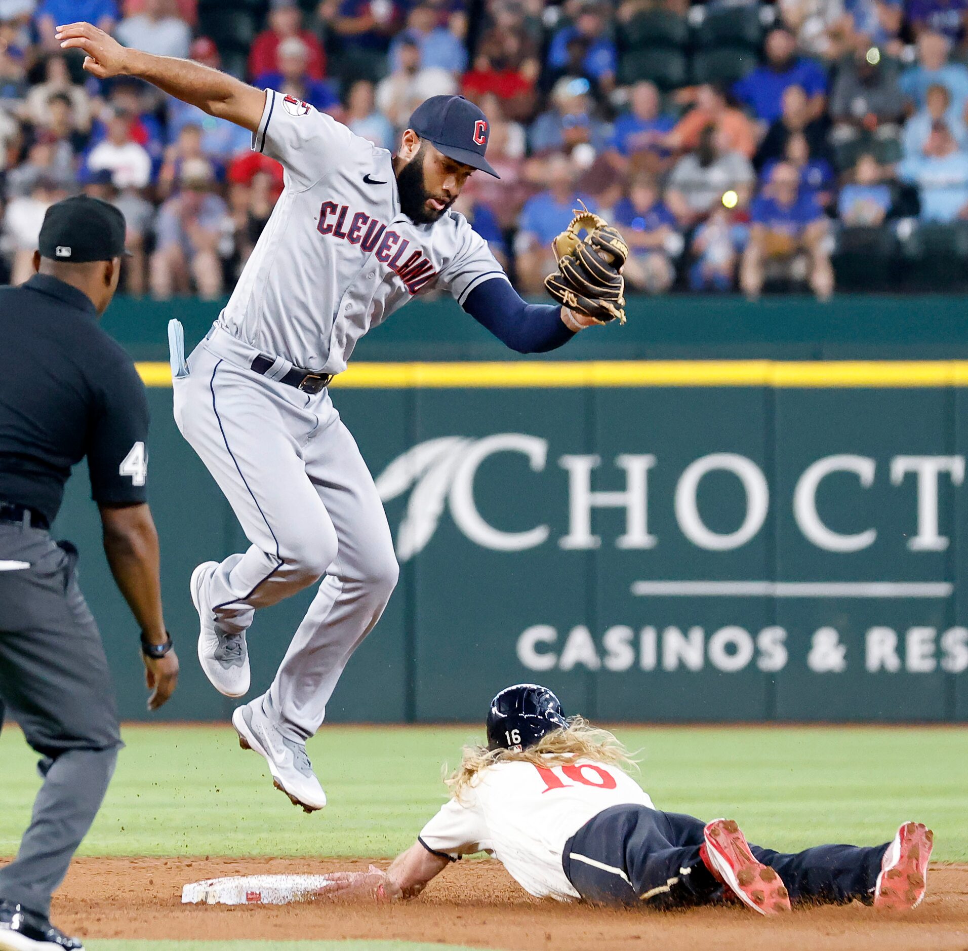 Cleveland Guardians shortstop Amed Rosario (1) goes high to get the throw down as Texas...