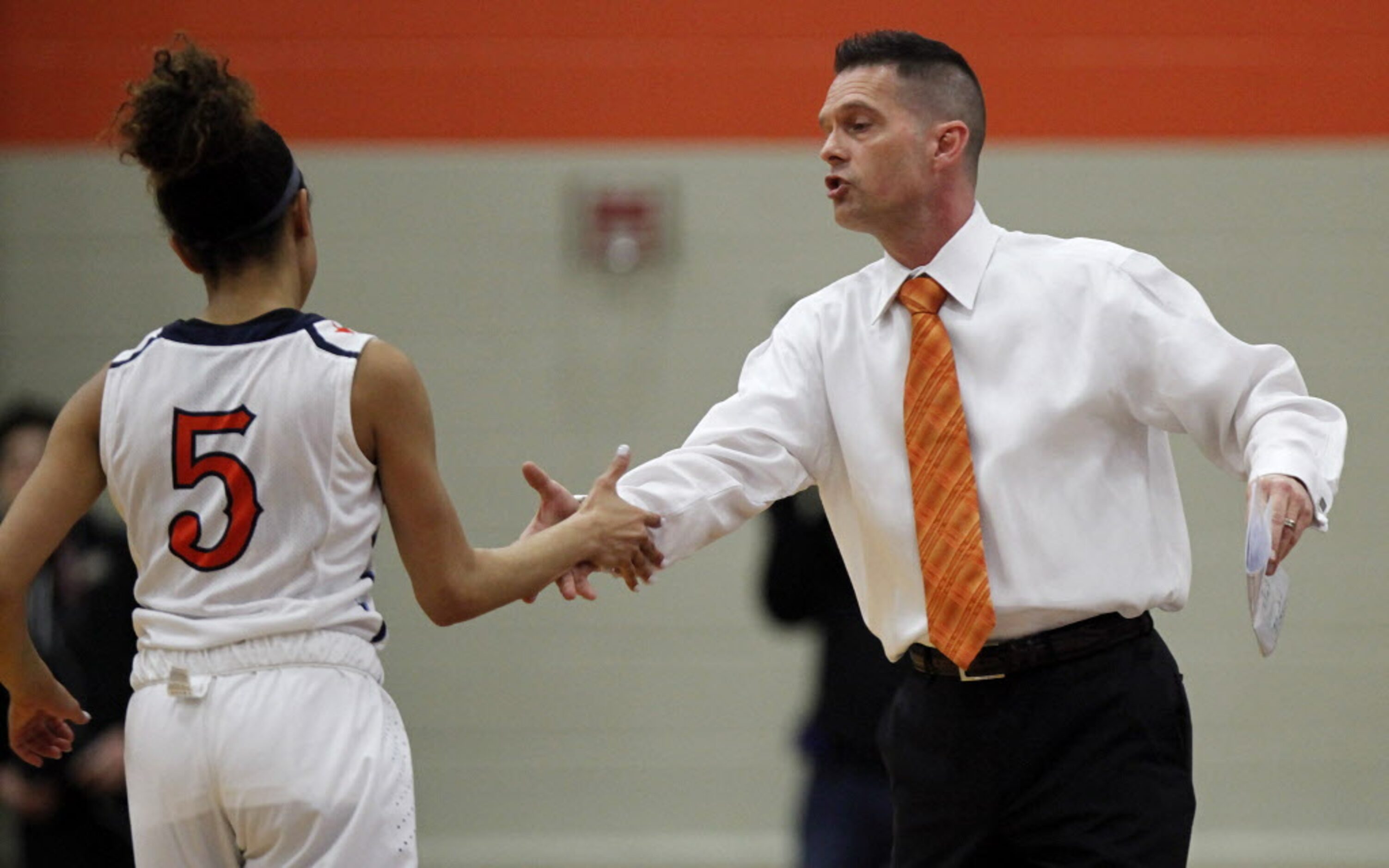 McKinney North head coach Michael Oldham (right) encourages his player, guard Lauren Foster...