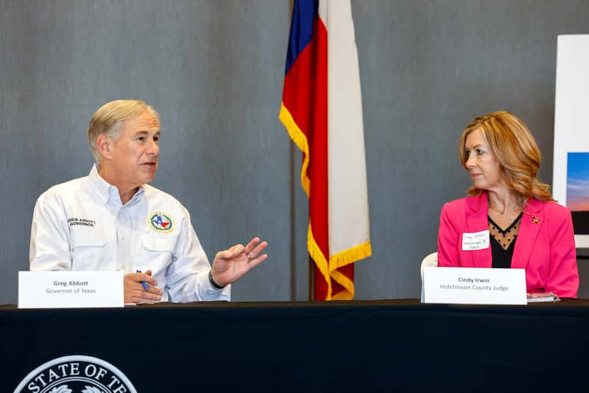 Texas Gov. Greg Abbott (left) speaks to Hutchinson County Judge Cindy Irwin during a...