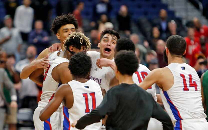 Duncanville players celebrate their 69-73 win against Klein Forest in a UIL boys basketball...