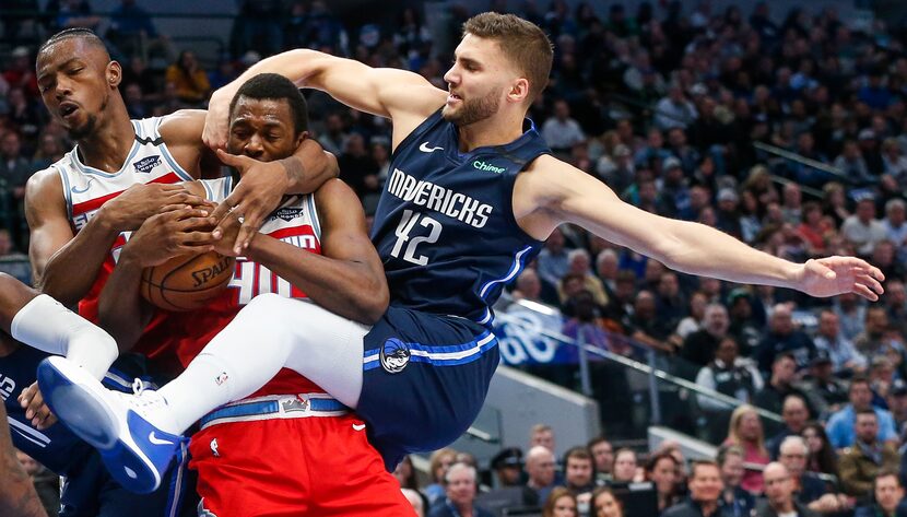 Mavericks forward Maxi Kleber tangled with Sacramento’s Harry Giles III (left) and former...