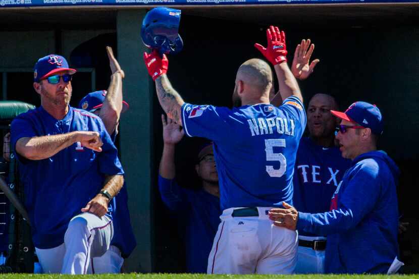 Texas Rangers first baseman Mike Napoli (5) gets high-fives from team mates in the dugout...
