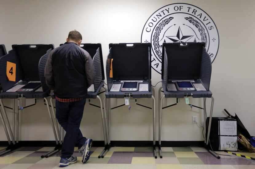 A voter casts his ballot at an early voting polling site, in Austin.  