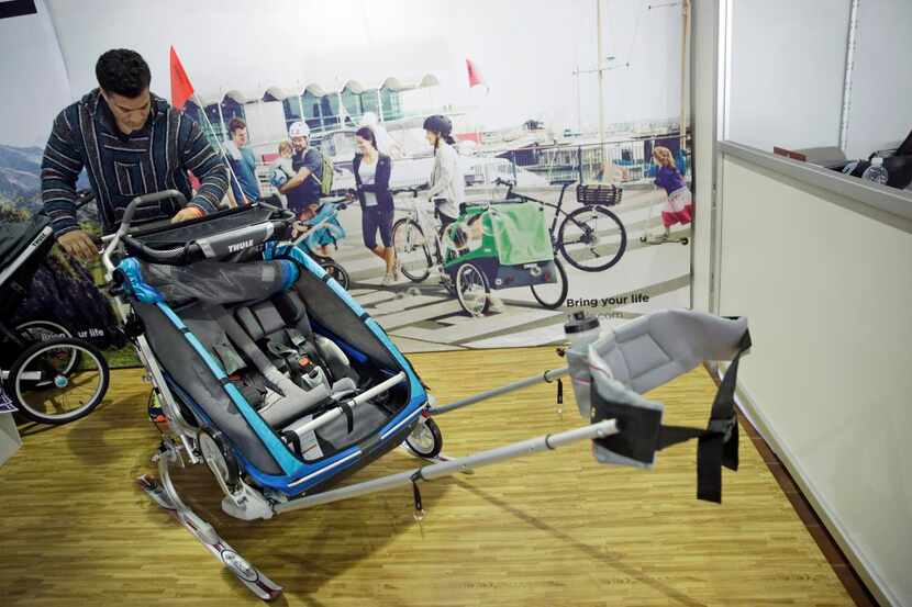 
 A visitor to the New York Baby Show inspects the Thule Chariot CX. 

