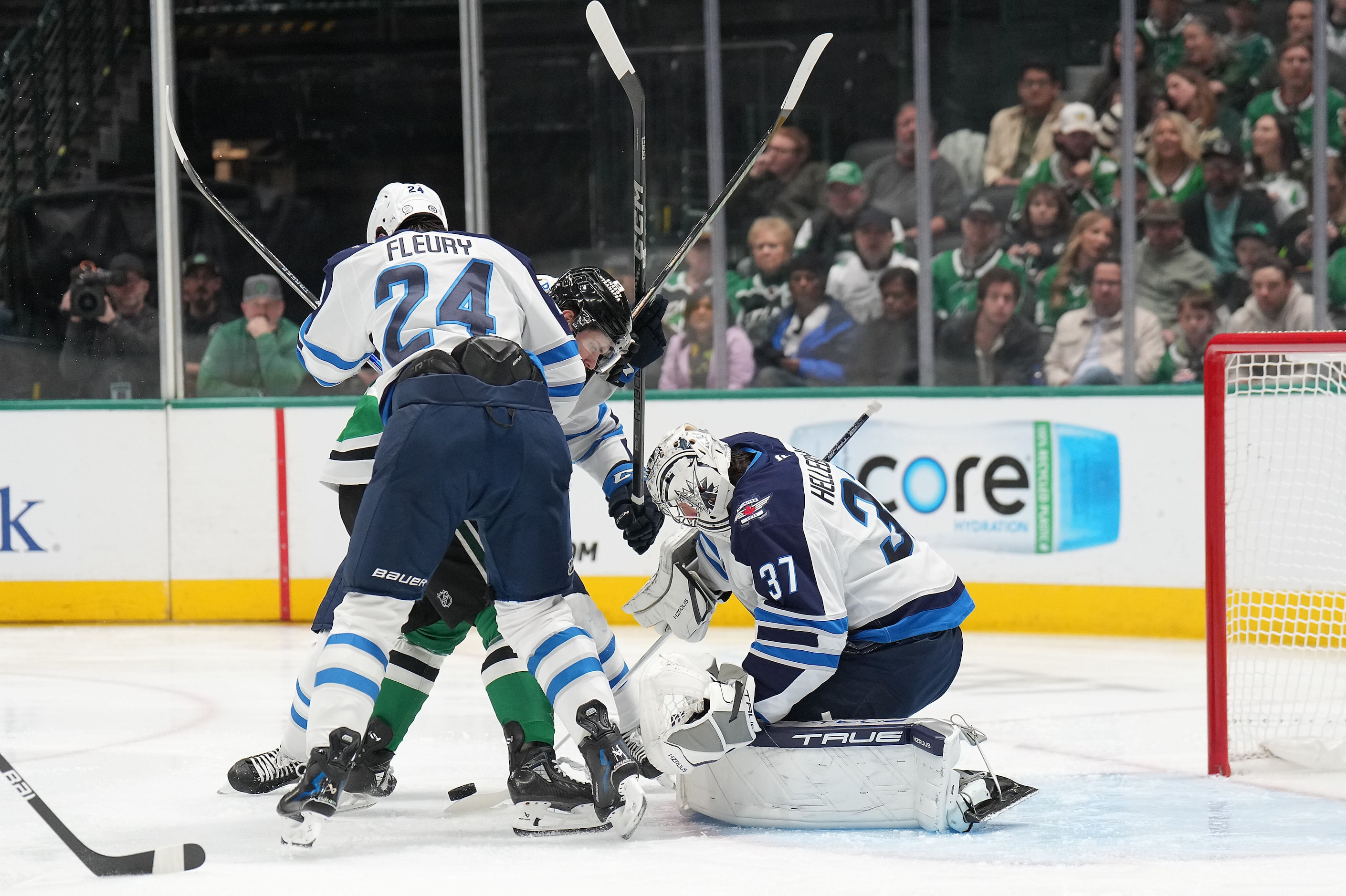 Winnipeg Jets goaltender Connor Hellebuyck (37) makes a stop on Dallas Stars center Sam...