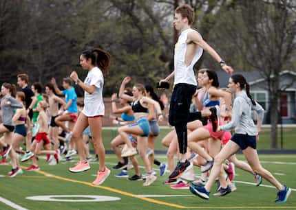 Southlake Carroll track runner Caden Leonard (center) warms up with his track teammates at...