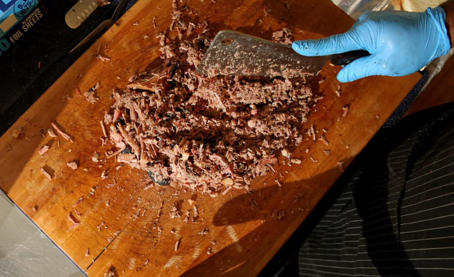 Abraham Franks chops brisket at Franks Holy Smoke BBQ in Ovilla.