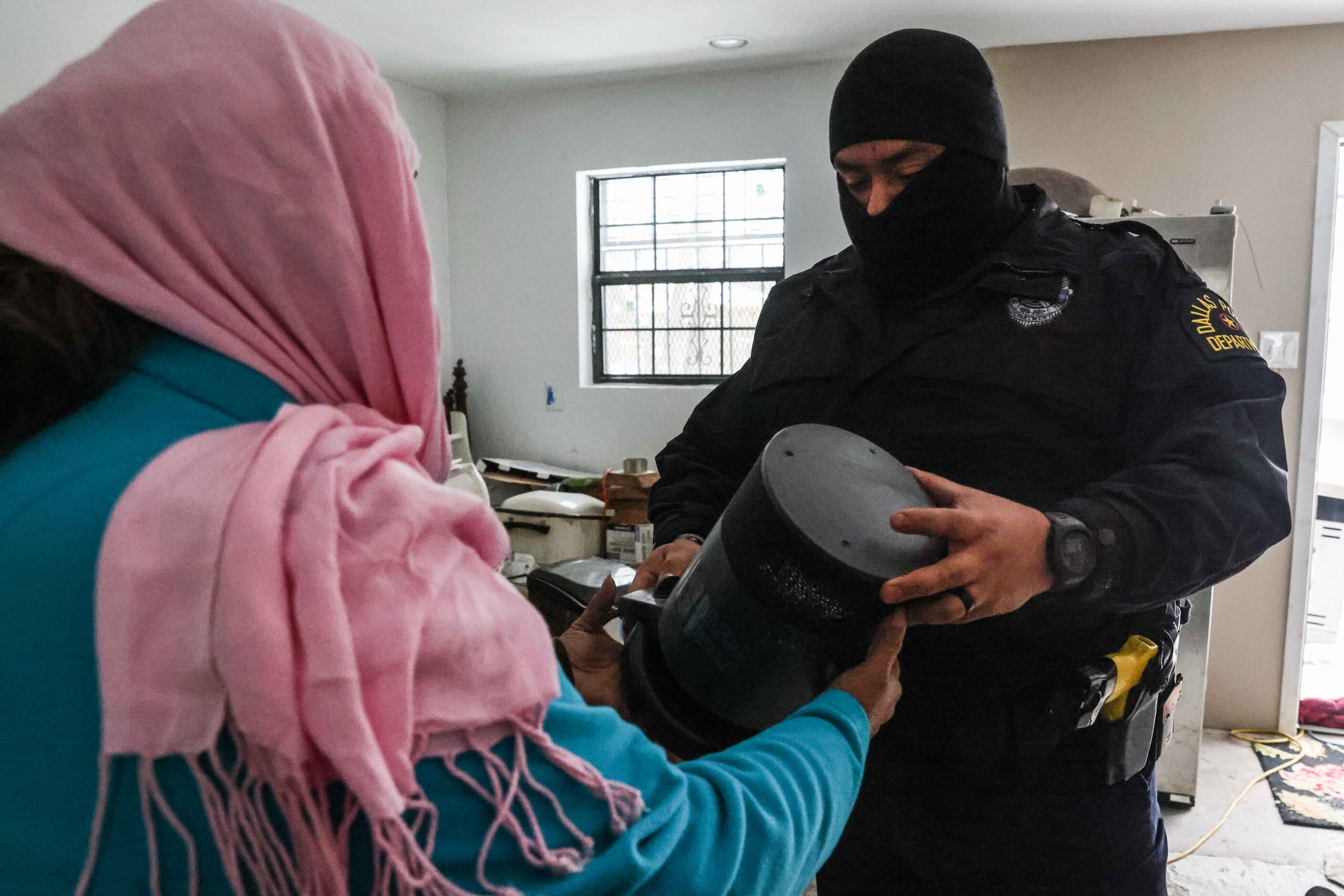 Dallas Police Officer Victor Guardiola brings a portable heater to Sylvia Cardona after...