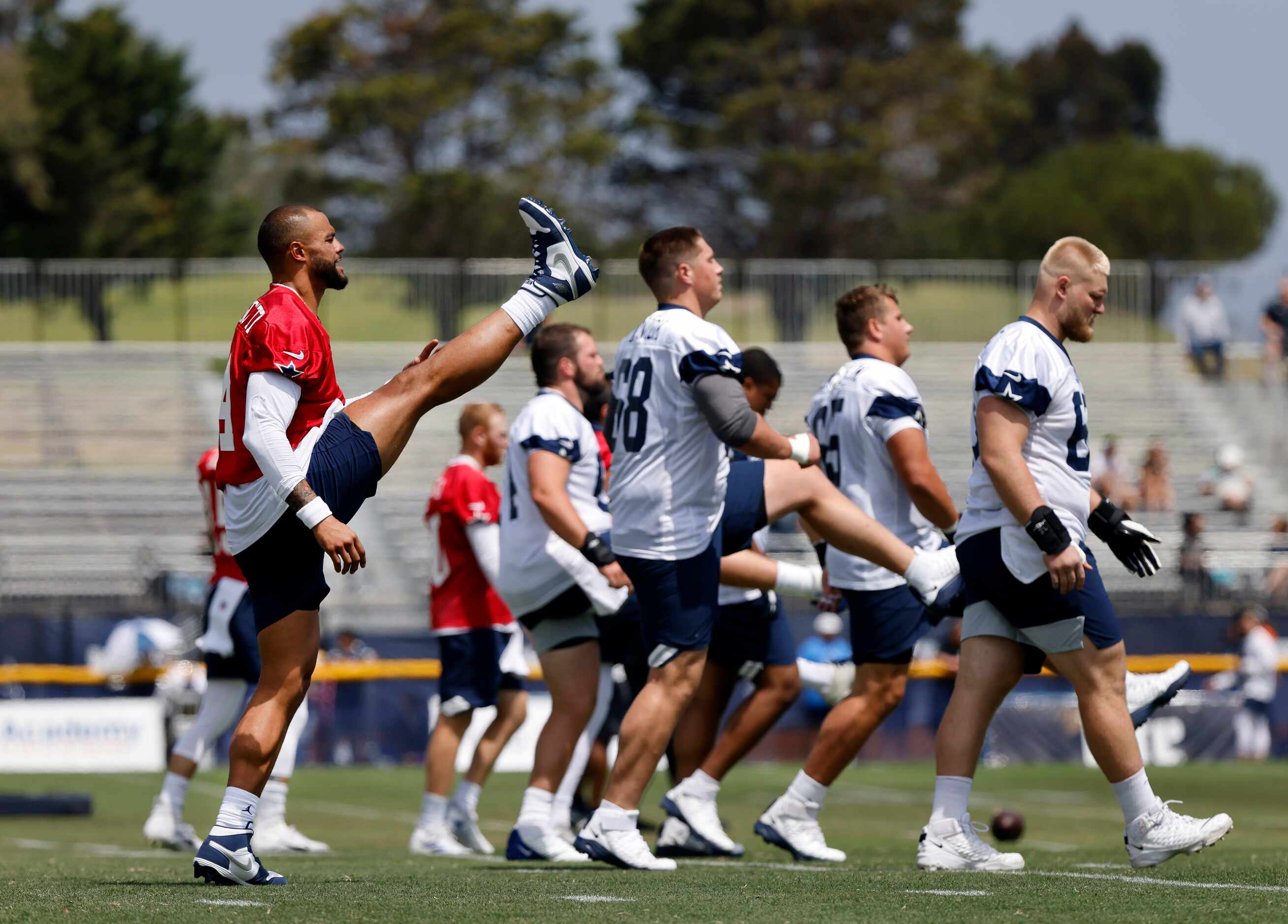 Dallas Cowboys quarterback Dak Prescott (4) stretches its high kicks as he and his lineman...