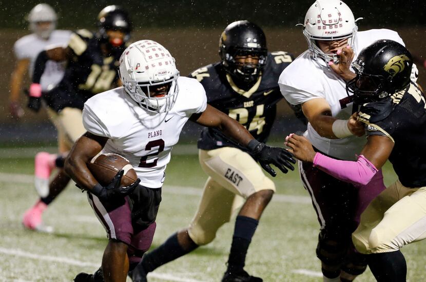 Plano RB Kyron Cumby (2) picks up a block by a teammate, as he rounds right end in route to...