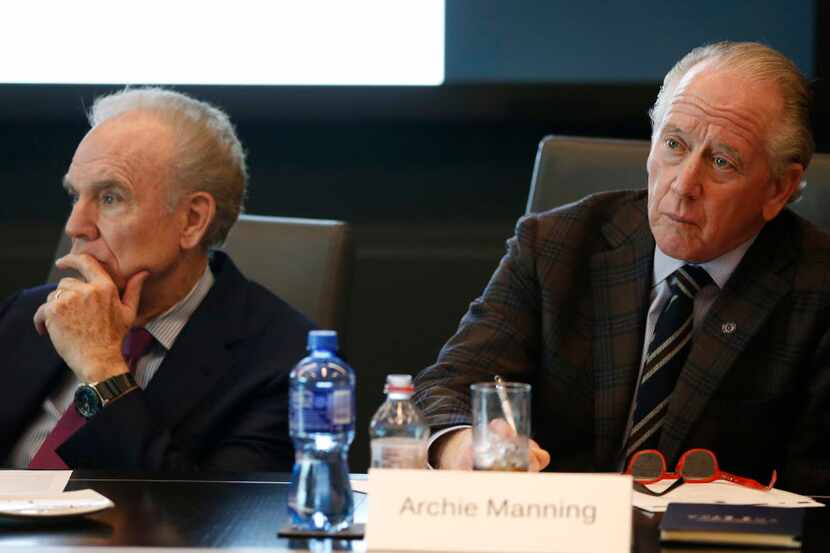 Archie Manning (right) and Roger Staubach listen to a presentation during a meeting to...