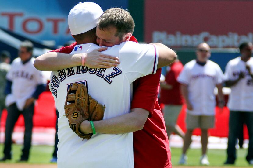 Newtown victim father Robbie Parker embraces former Texas catcher Ivan "Pudge" Rodriguez...